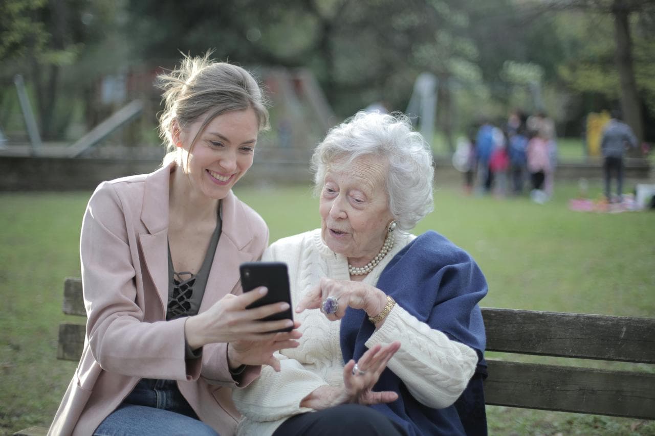 An elegant elderly man ready for an outing, with his supportive carer nearby.